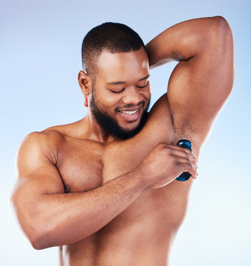 Deodorant, Skincare and Black Man for Beauty, Grooming and Body Hygiene on Blue Background. Wellness, Health and Male Smile with Antiperspirant, Fragrance and Scent Product for Underarm in Studio