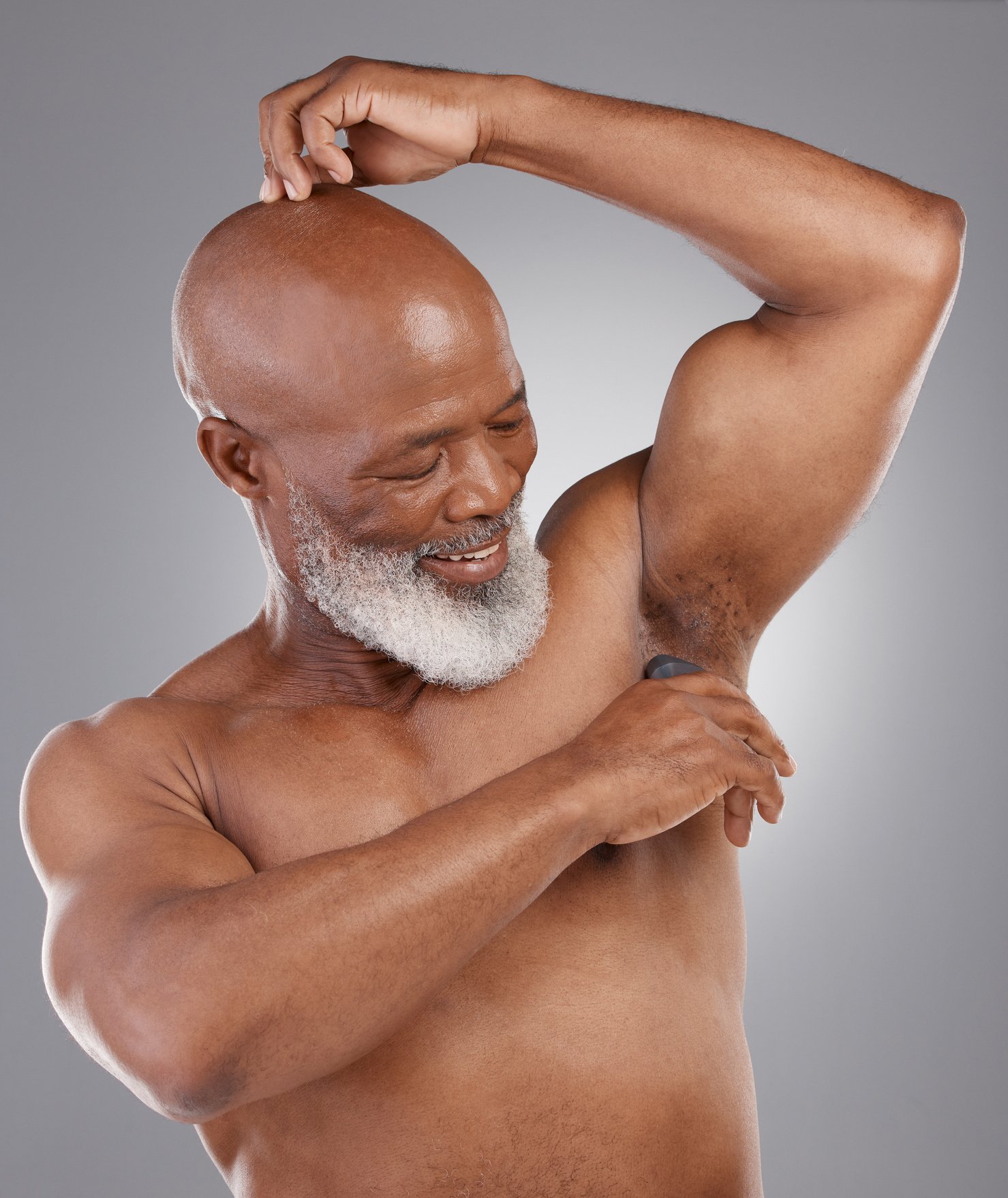 Senior Black Man, Deodorant and Armpit for Skincare, Grooming or Person Hygiene against a Gray Studio Background. Happy Elderly African American Male Applying Cosmetics for Fresh or Clean Smell